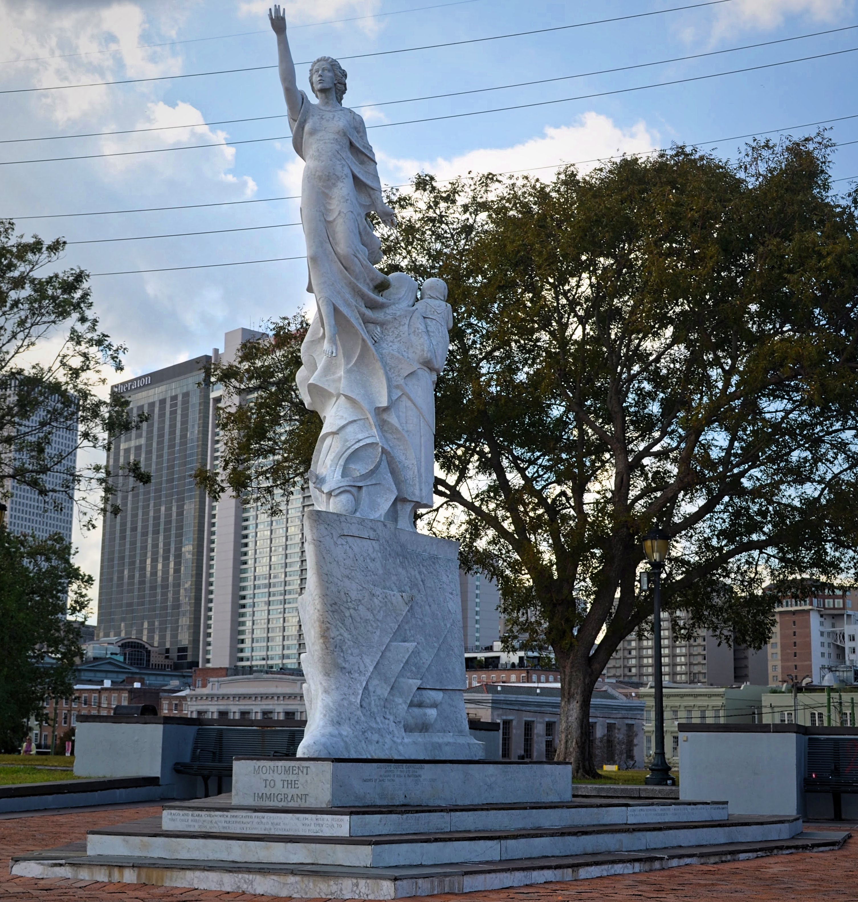 Statue of the immigrants white statue of woman with one hand in the air, new Orleans, travel blog, new orleans Louisiana, NOLA, the big east, new Orleans photography, Atlanta photographer, new Orleans travel, new Orleans travel blog, traveling blog, immigrants, new Orleans statues, new Orleans monuments, 